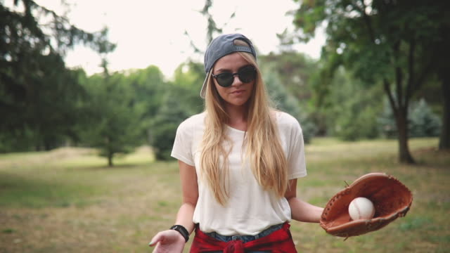 Beautiful retro looking girl playing baseball outdoors