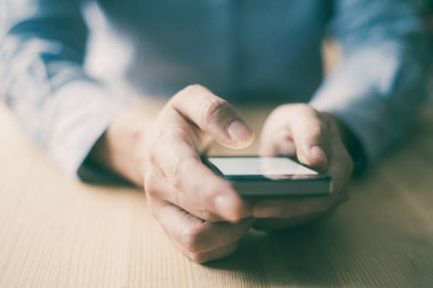 istock Closeup of Person Using Smartphone at Desk 1028168472