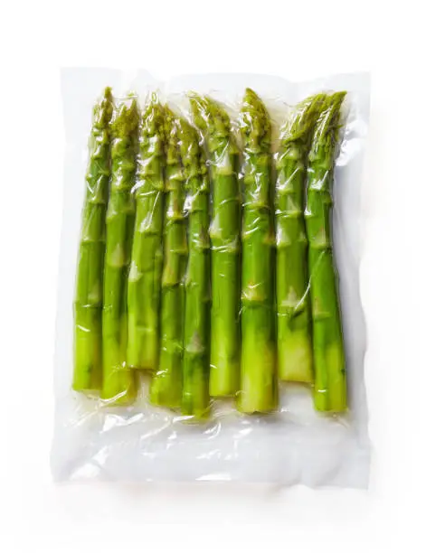 Fresh asparagus vacuum sealed rady for sous vide cooking, isolated on white background, top view