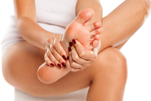 istock woman massaging her tired feet on white background 1028171714