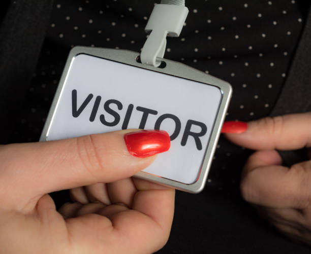 istock Woman holding visitor badge close up 1028177704