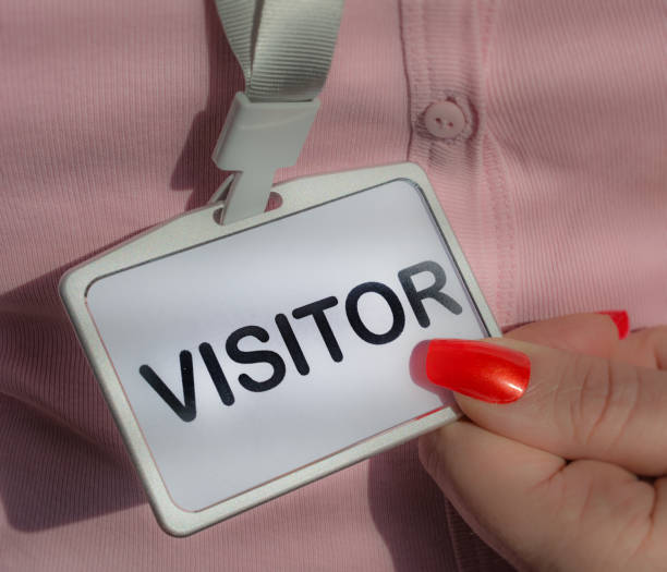 Woman holding visitor badge close up