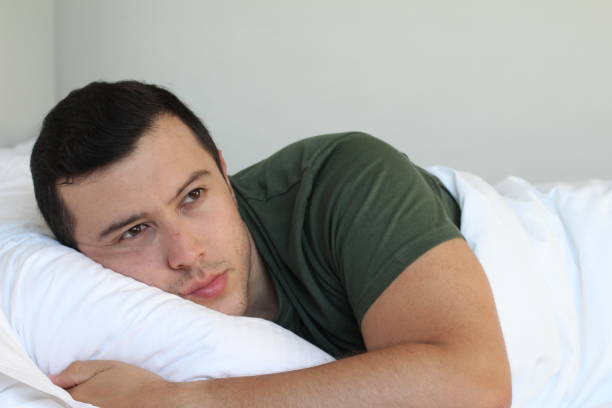 istock Heartbroken young man laying down in bed 1028184224