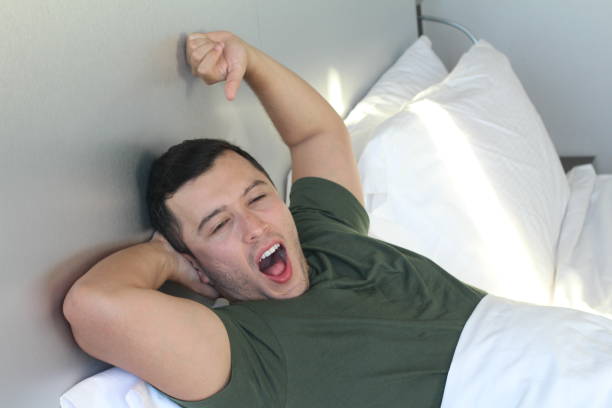 istock Young male yawning in bed 1028187894