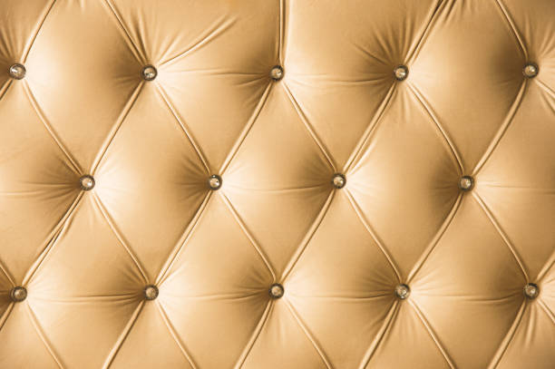 istock Beige soft textile background with symmetrical buttons on the corners of diamonds. Soft and expensive furniture elements. Luxury background 1028188324