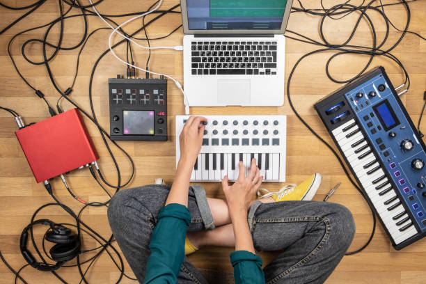 istock Woman making electronic music on laptop computer and digital instruments. 1028188420