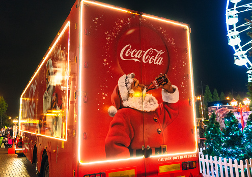Manchester, UK - An image of Santa Claus drinking Coca-Cola on the back of the company's touring Christmas marketing truck in Manchester, England, with people in the background.