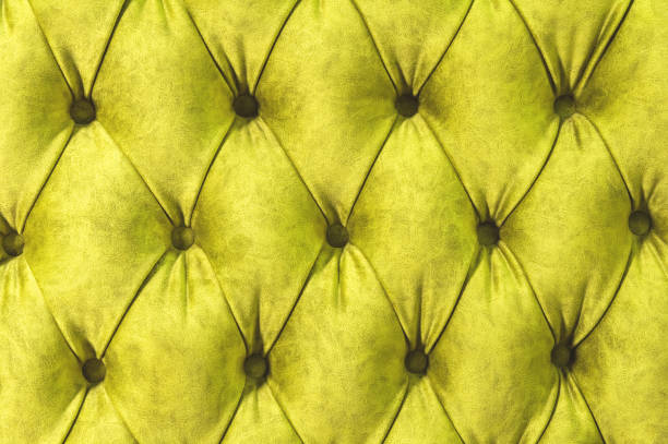 istock Velor surface of sofa close-up. Training equipment-velor mats tightened with buttons. Yellow chesterfield style quilted upholstery background close up 1028193442