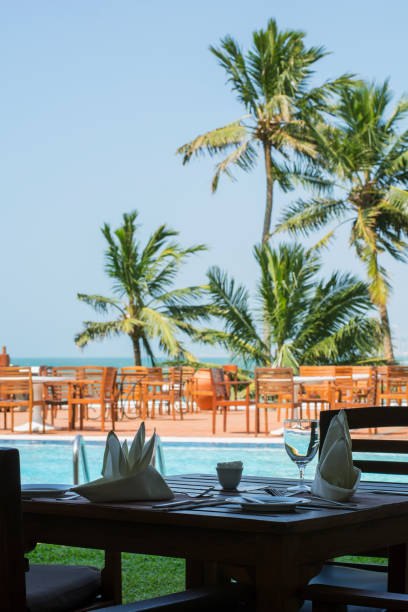 istock A table for two people near a swimming pool with palm trees 1028193670