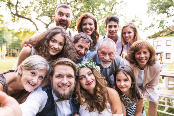 Bride, groom with guests taking selfie at wedding reception outside in the backyard. A close-up of happy bride, groom with guests taking selfie at wedding reception outside in the backyard. guest photos stock pictures, royalty-free photos & images