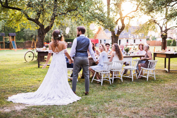 istock Bride and groom holding hands at wedding reception outside in the backyard. 1028207148