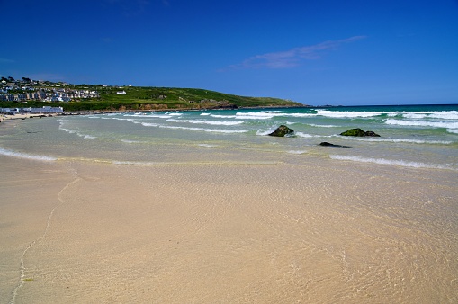 Looking towards the surf at Porthmeor Beach on a sunny St Ives day in Cornwall.