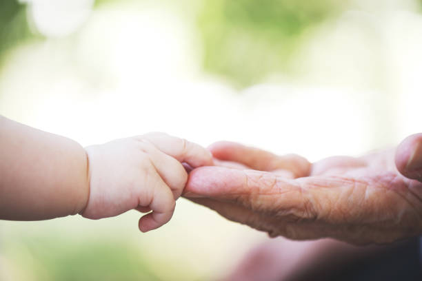 istock Baby hand and grandmother hand 1028211202
