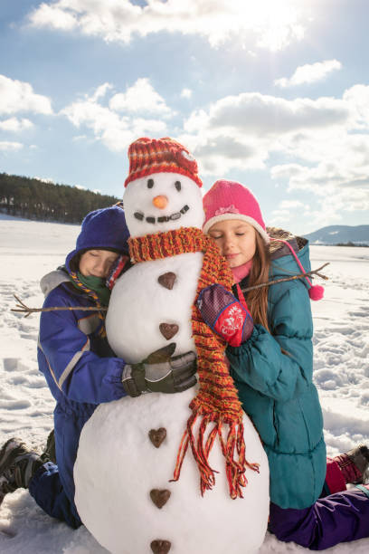 istock Boy and girl making snowman 1028212072