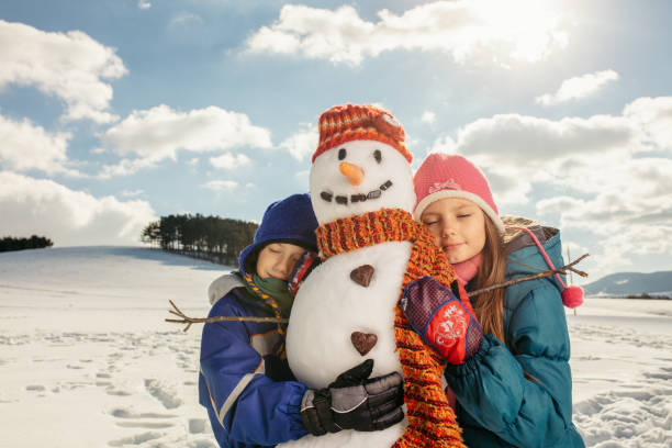 Boy and girl making snowman