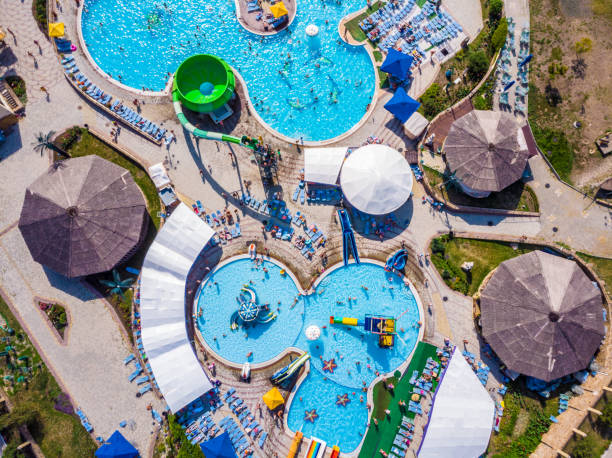 vista aérea drone mirando hacia abajo desde arriba de colorida diversión verano en parque acuático - floating on water swimming pool men water fotografías e imágenes de stock