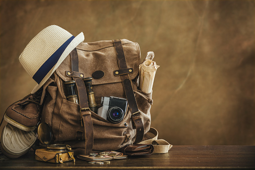 Looking image of travelling concept, essential vacation items. Backpack. Retro effect.