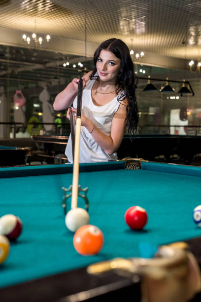 istock Woman with cue on bridge going hit a ball 1028229878