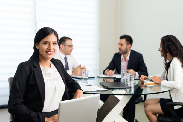 istock Female executive sitting in meeting and smiling at camera 1028234376