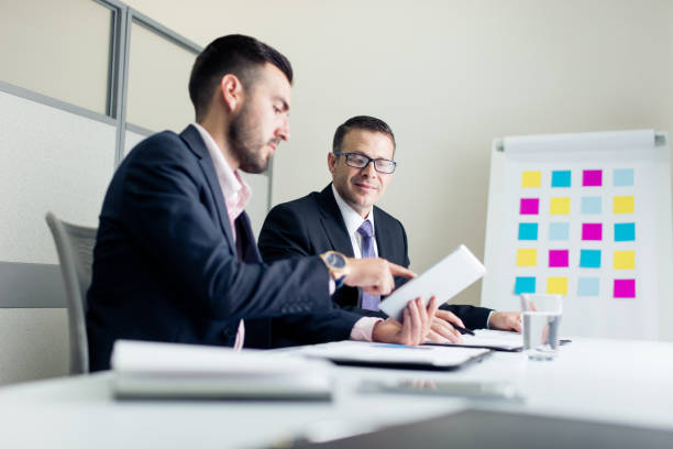 istock Two business male executives sitting and discussing work 1028234972