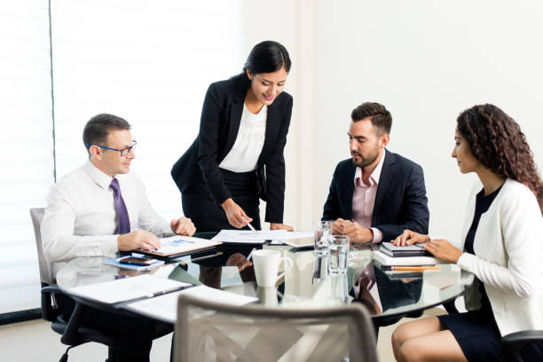 istock Four latin executives sitting at round table and looking at documents 1028237404