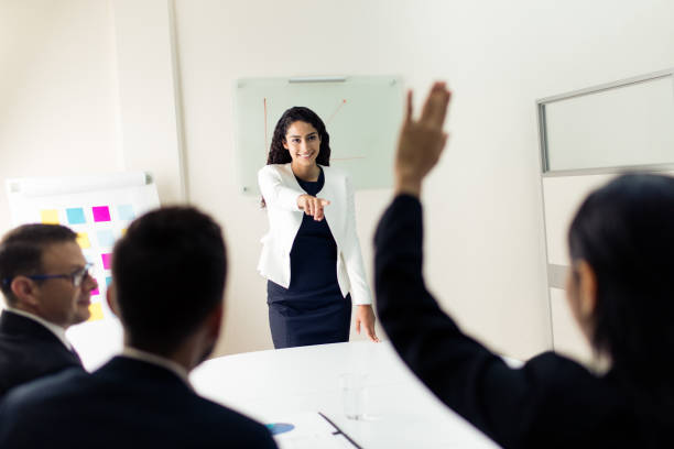 istock Female executive giving presentation and pointing to colleague 1028238050