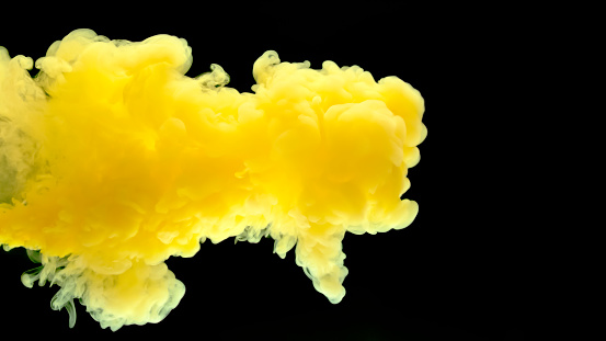Close-up of yellow smoke drifting against black background.