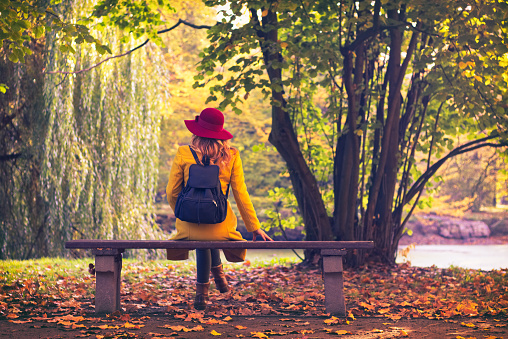 Girl wearing yellow coat and red hat relax in nature