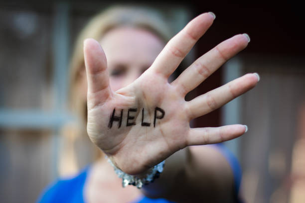 istock Woman gesturing help sign on her hand. 1028246768