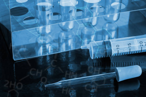 Pipette and Syringe science laboratory equipment on black table.