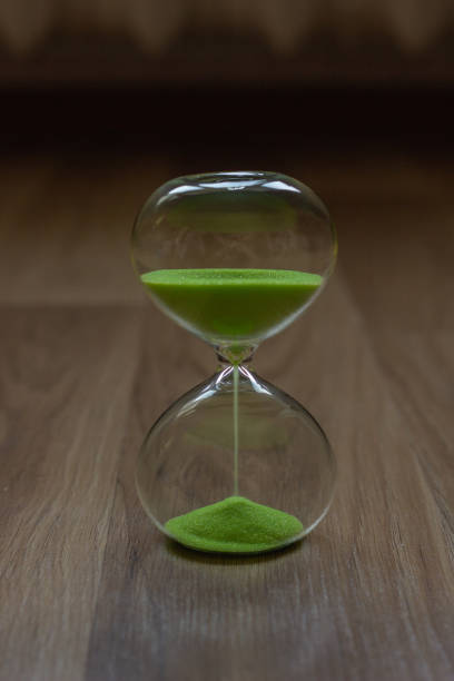 istock Close-up, hourglass on a wooden table, blurred background 1028259374