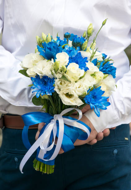 istock Groom with a wedding bouquet in hands 1028259714