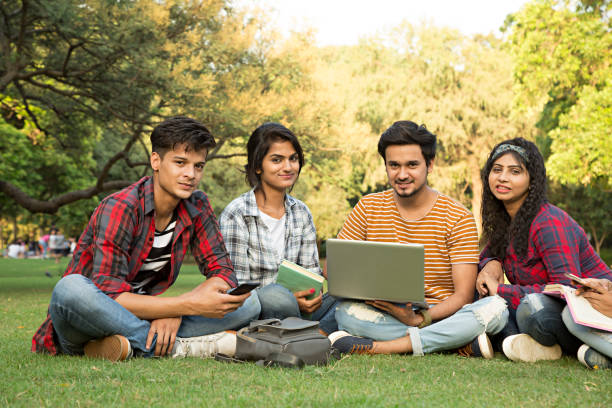 Team of Indian university students doing group study. - Stock image India, University, Campus, School Building, Reading teenager adolescence campus group of people stock pictures, royalty-free photos & images