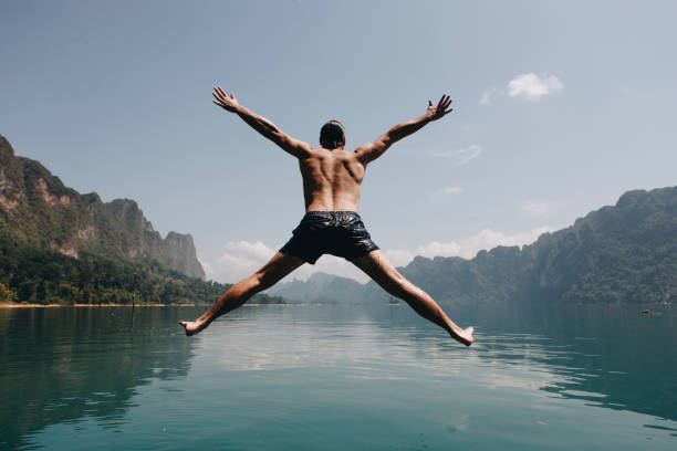 istock Man jumping with joy by a lake 1028268986