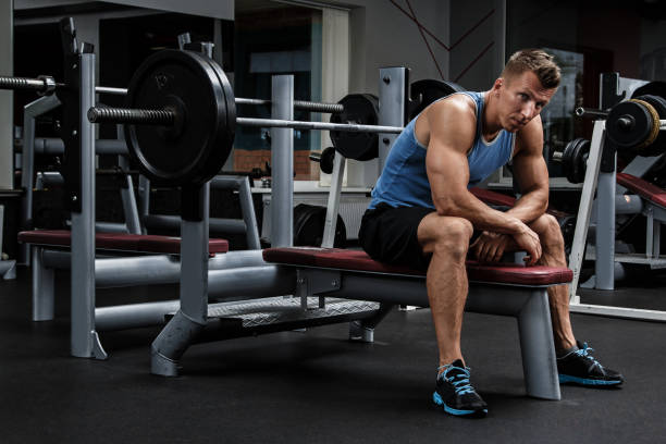 Man during bench press exercise Man during bench press exercise in gym Barbell stock pictures, royalty-free photos & images