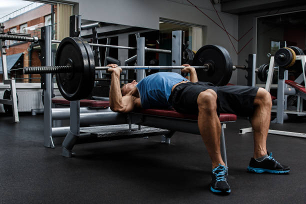 hombre durante el ejercicio de levantamiento de pesas en banco - muscular build men human muscle body building exercises fotografías e imágenes de stock