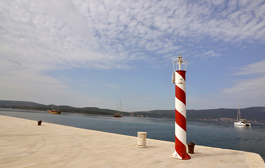 Beacon on the red and white pole, on the dock