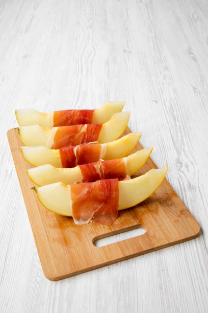 istock Melon slices wrapped in prosciutto, side view. Copy space. 1028290266