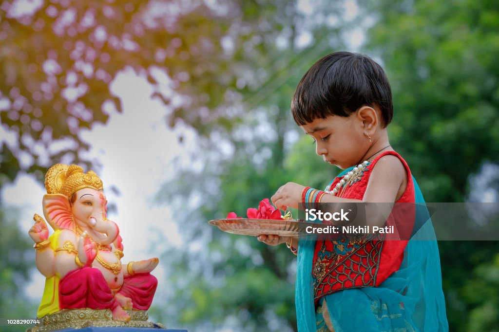 Little Indian girl child with lord ganesha and praying , Indian ganesh festival Ganesh Chaturthi Stock Photo