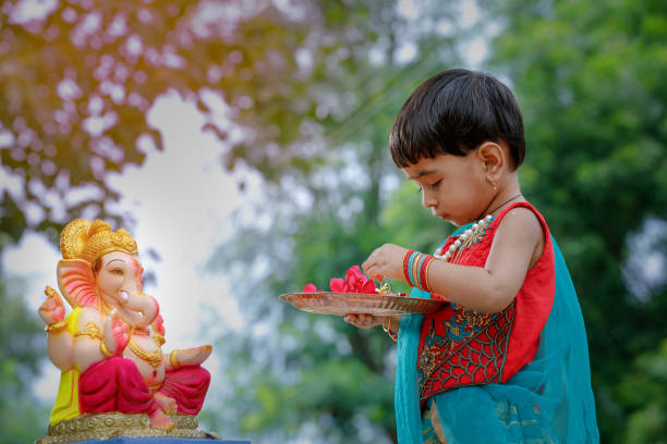 Little Indian girl child with lord ganesha and praying , Indian ganesh festival Little Indian girl child with lord ganesha and praying , Indian ganesh festival ganesh chaturthi photos stock pictures, royalty-free photos & images