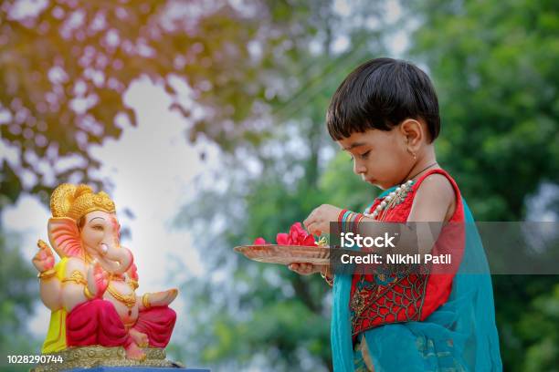 Little Indian Girl Child With Lord Ganesha And Praying Indian Ganesh Festival Stock Photo - Download Image Now