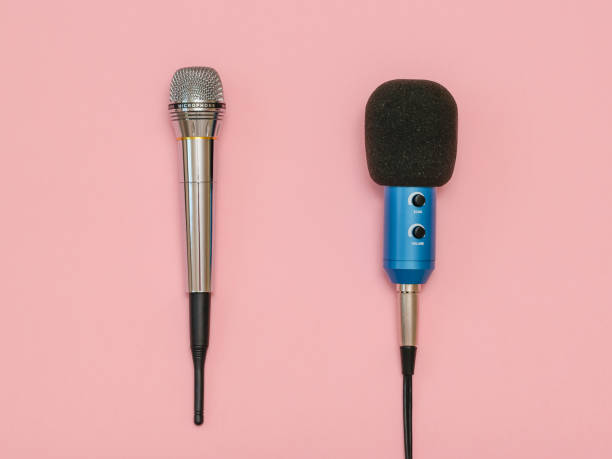 istock Wireless microphone, classic microphone with wire on a light pink background. Flat lay. 1028305804