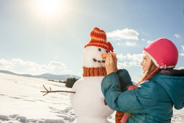 istock Girl making a snowman 1028309850