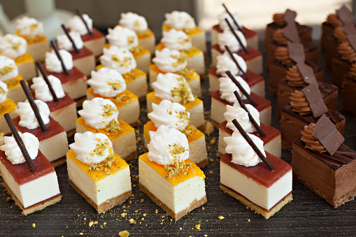 Small chocolate and vanilla layered cakes in rows on candy buffet. Sweet paradise.