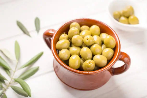 Green olives in rustic bowl