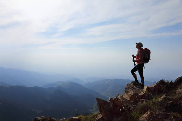 istock Lady hiker with backpack standing on top of the mountain 1028339892