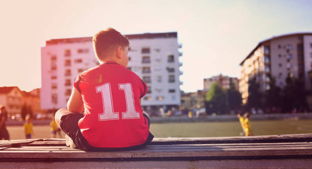Sad little basketball player sitting on a bench