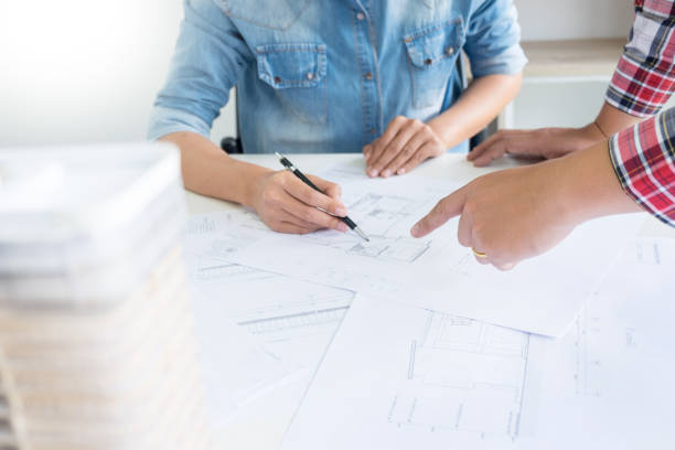 istock Coworkers Discussing Blueprints In Office 1028339914
