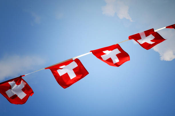 istock Low Angle View Of Swiss Flags Hanging Against Sky 1028340142
