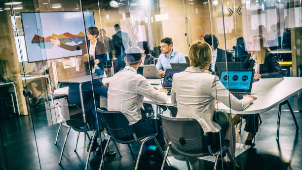 istock Female financial analyst giving presentation to board members 1028343602